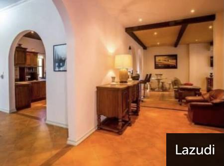 Open living area with seating and access to kitchen through archway