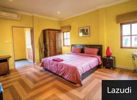 Bedroom with double bed, windows, and wooden floor