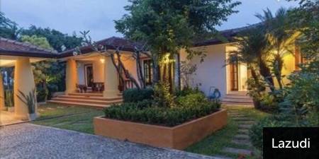 Exterior view of a single-story house with garden and outdoor lighting
