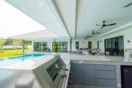 Covered outdoor patio with built-in grill and seating area
