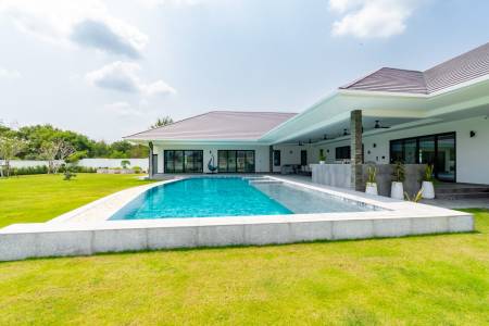 Outdoor swimming pool area beside a modern single-story house