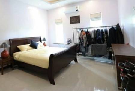 Bedroom with bed, side tables, clothing rack, and desk