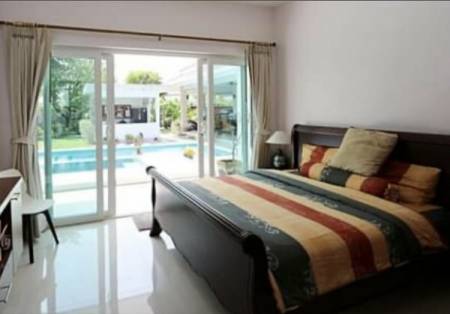 Bedroom with large sliding doors opening to a pool view