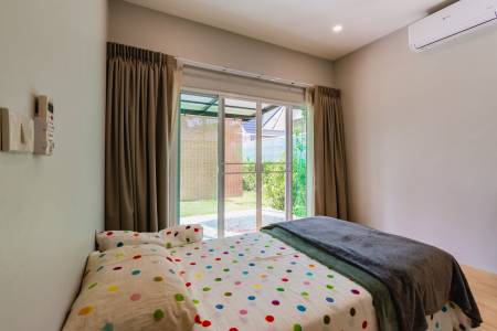 Bedroom with sliding glass door opening to a garden area
