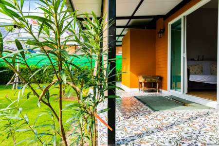 Covered balcony with patterned floor tiles overlooking garden